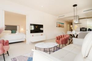 a white living room with a white couch and a table at Jardinana - apartment with two bedrooms close to beach and town center in La Cala de Mijas