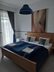 um quarto com uma cama grande e um cobertor azul em Hédervári Lovas Vendégház em Hédervár