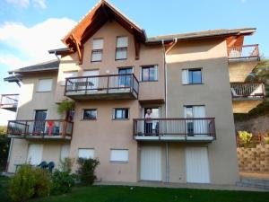 a building with balconies and people standing on them at Appartement Savines-le-lac, aan het meer van Serre-Ponçon te huur per week van zaterdag tot zaterdag par semaine complète de samedi à samedi in Savines