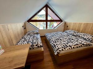 2 camas en una habitación con ventana grande en Apartmány BARTH Holiday - Špindlerův Mlýn en Špindlerův Mlýn