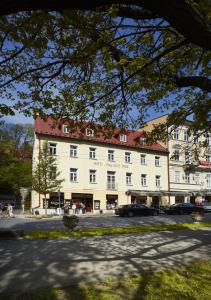 ein großes weißes Gebäude mit rotem Dach in der Unterkunft OREA Place Marienbad in Marienbad