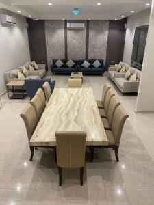 a conference room with a table and chairs and couches at شاليهات حديقة الوسام لبيوت العطلات 2 in Taif +19 photos