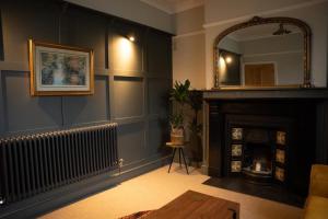 a living room with a fireplace and a mirror at Cosy Village House in Waddington