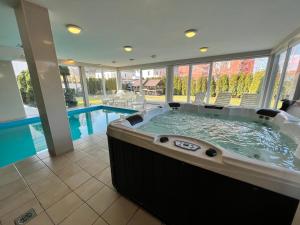 a large hot tub in a room with a pool at Wellness Dorina in Siófok +26 photos