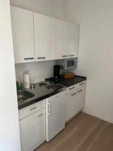 una cocina con armarios blancos y fregadero en Kleines zentrales Apartment in Goch - Netflix en Goch