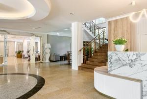 a lobby with a staircase with a marble counter at Hotel Antoni in Tomaszów Lubelski