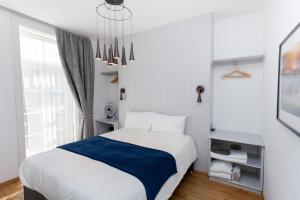 a bedroom with a white bed with a blue blanket at Number 8 in Canterbury