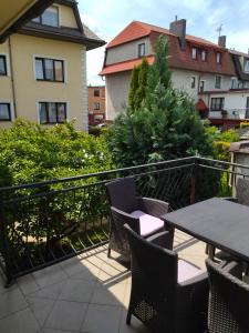 a patio with a table and chairs on a balcony at Karolinka Łeba in Łeba