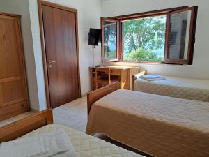 阿西西Casa per Ferie Ulivo d'Assisi的有两张床和一扇窗户的酒店房间