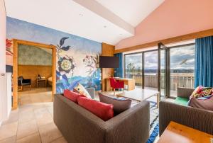 a living room with two couches and a large window at Allgäu-Hotel-Elbsee in Aitrang