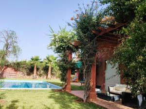 une maison avec une piscine dans une cour dans l'établissement Villa Apricot - Golf Amelkis, à Marrakech