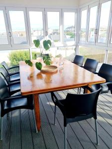 a wooden table in a room with chairs at Coral Cottage in Struisbaai