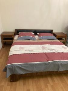 a bed with two pillows on it with two tables at Apartment Kostava 10 in Batumi
