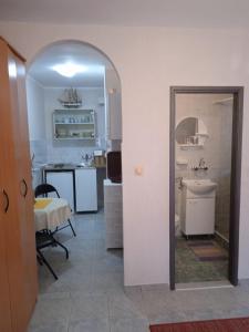 a room with a kitchen with a table and a mirror at Apartmani Padrov in Igalo