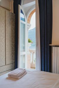 sypialnia z łóżkiem i otwartym oknem w obiekcie Briisa De Ness w mieście Nesso