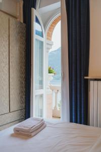 een slaapkamer met een bed en een open raam bij Briisa De Ness in Nesso +32 foto's