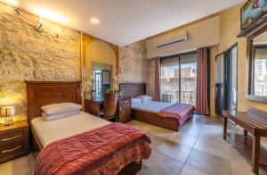 um quarto de hotel com duas camas e uma secretária em New Imperial Hotel em Jerusalém