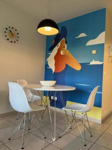 a table and chairs in a room with a mural at Studio Blanchard in Koksijde