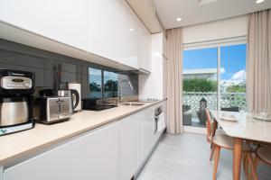 une cuisine avec un comptoir et une table avec des chaises dans l'établissement STUDIO apartment near Seven Mile Beach at The Grove, à Upper Land