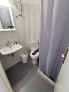a bathroom with a toilet and a sink at KR Apartments in Aliki