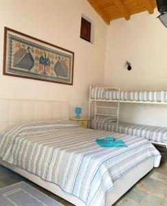 a bedroom with a bed and a picture on the wall at Locanda Nina e lu Entu di Supra in Marina di Portisco