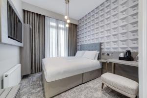 a hotel room with a bed and a desk at Mornington Victor Hotel London Belgravia in London