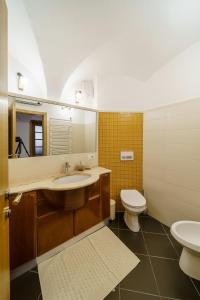 a bathroom with a sink and a toilet and a mirror at Guest House Žerjal in Podnanos