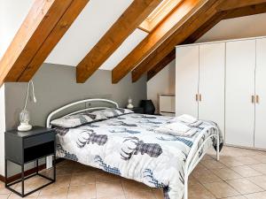 a bedroom with a bed and a wooden ceiling at Mansarda Bucaneve in Craveggia