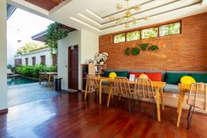 ein Esszimmer mit einer Ziegelwand, einem Tisch und Stühlen in der Unterkunft Cove Ransha Stay in Sanur