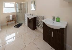 La salle de bains est pourvue d'un lavabo et d'une douche. dans l'établissement Clonea Beach Houses, à Dungarvan