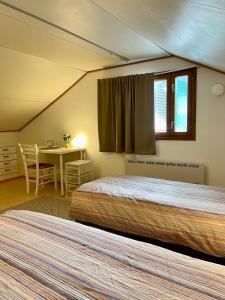 two beds in a room with a table and a window at Villa Salir - bedroom, kitchen and bathroom 
