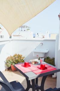 a table with a red table cloth on a balcony at Casa Viola -Locazione Breve in Polignano a Mare