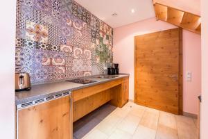 a kitchen with a sink and a wooden wall at Allgäu-Hotel-Elbsee in Aitrang