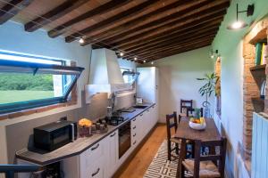 een keuken met witte kasten, een fornuis en een raam bij Casanova di Campriano in Lupompesi