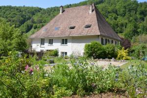 una gran casa blanca con techo en Moulin de la Cuse - Chambre l'Anse, en Cusance