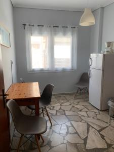 een keuken met een tafel en stoelen en een koelkast bij Agni in Nafpaktos