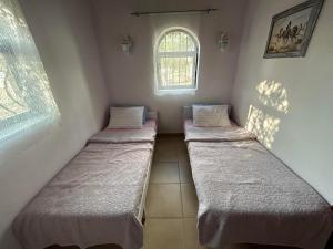 three beds in a room with a window at sweet horses ST6 in Didim