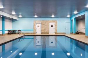 a swimming pool in a gym with blue walls at Travelodge by Wyndham Simcoe in Simcoe