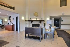 a living room with a table and a fireplace at Super 8 by Wyndham Trois-Rivieres in Trois-Rivières