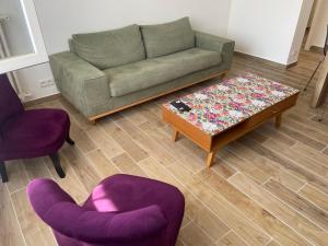 a living room with a couch and two chairs and a table at La Serane Appartement T3 in Marseille