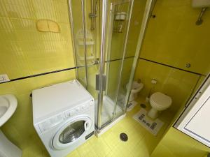 un piccolo bagno con lavatrice e servizi igienici di House Vacations Center a Castellammare di Stabia Altre 17 foto