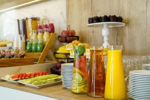 a bunch of juice bottles on a counter with plates at Hotel Antoni in Tomaszów Lubelski
