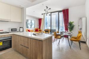 a kitchen and living room with a table and chairs at Vivid 2-bedroom Marina view in Dubai