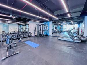 a gym with several treadmills and machines at Vivid 2-bedroom Marina view in Dubai