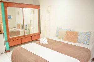 a bedroom with two beds and a large mirror at Villa Geriba in Búzios