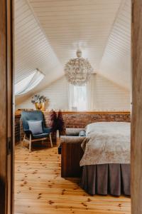 Schlafzimmer mit einem Bett und einem Kronleuchter in der Unterkunft SPA NAMIŅŠ in Valmiera