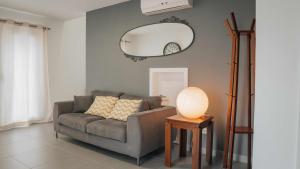 a living room with a gray couch and a mirror at Casa do Parque Casa familiar in Nordeste
