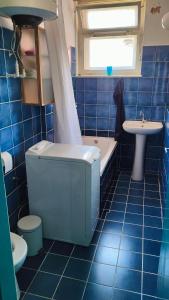 a blue tiled bathroom with a toilet and a sink at Maestral in Koper