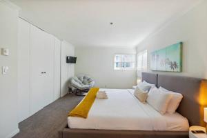 Un dormitorio con una cama grande con una manta amarilla. en Seas the Day by Cardo - La Jolla Beachfront, en San Diego