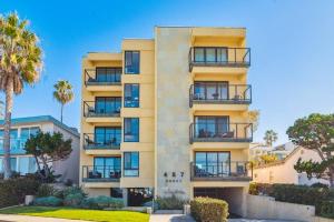 un edificio de apartamentos con balcones y palmeras en Seas the Day by Cardo - La Jolla Beachfront, en San Diego